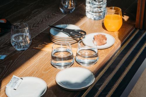 a table with plates and glasses of water and orange juice at 囲み宿 こわね in Tonosho