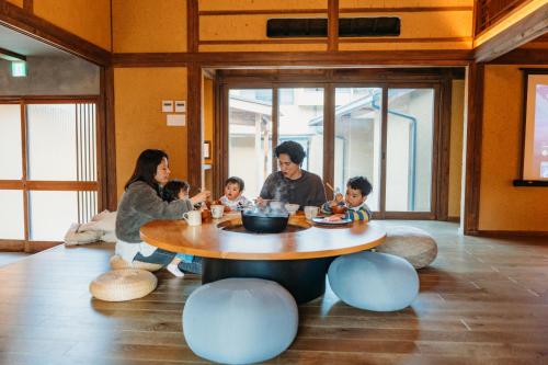 a family sitting around a table in a room at 囲み宿 こわね in Tonosho
