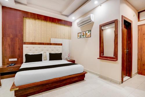 a bedroom with a large bed and a mirror at Townhouse Oak Dehradun Court Formerly GK Residency in Dehradun