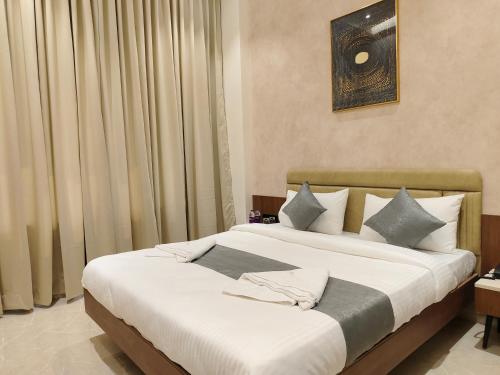 two beds in a hotel room with curtains at Hotel Raas Vrindavan in Laling