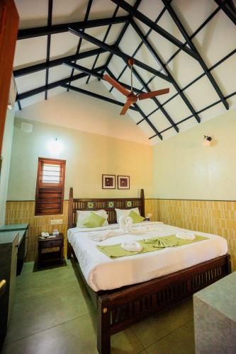 a bedroom with a large bed with a ceiling at Green Planet Resort in Mattanūr
