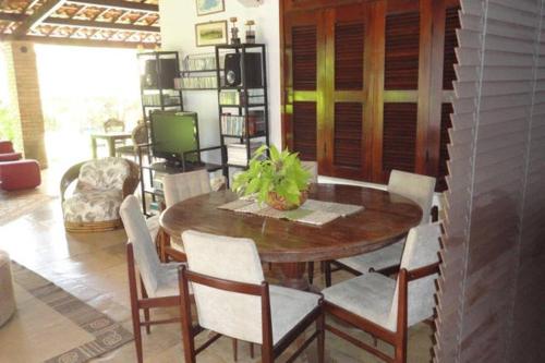 een eetkamer met een houten tafel en stoelen bij BH Studio Casa grande em Fortaleza in Fortaleza