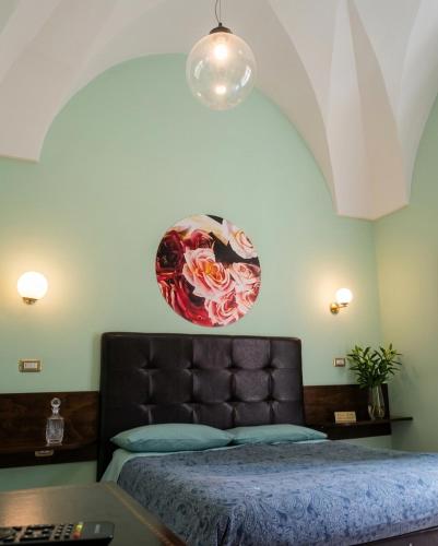 a bedroom with a bed with a flower decoration on the wall at Piazza Verdi Liberty House in Lecce