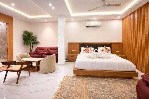 a bedroom with a bed and a couch and chairs at Orchha River Stone Resort in Orchha