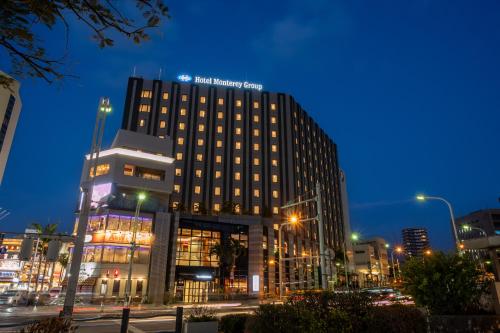 a tall building in a city at night at Hotel Monterey La Soeur Naha in Naha