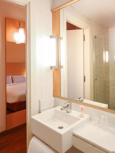 a white bathroom with a sink and a mirror at ibis Buenos Aires Obelisco in Buenos Aires