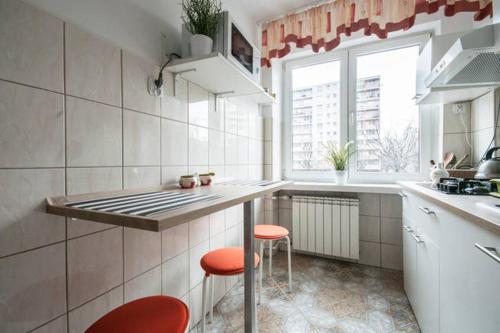 a kitchen with two stools and a counter in a room at Center Warsaw - Apartament Jana Pawła in Warsaw