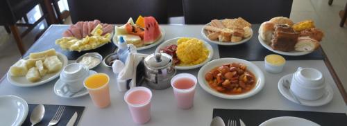 een tafel met borden ontbijt erop bij Tropical Praia Hotel in Aracaju