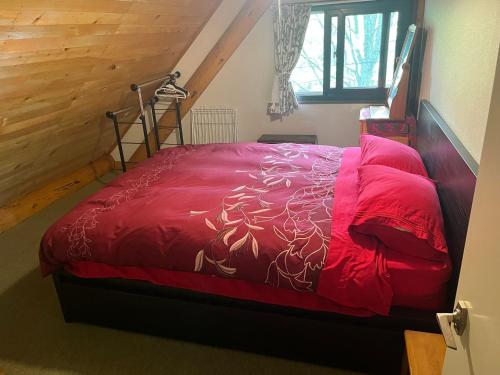 a bedroom with a bed with a red comforter at Appi Ski Chalet in Hachimantai