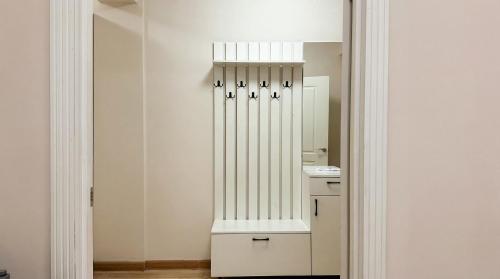 a white bathroom with a sink and a mirror at Cozy Almaty Escape in Almaty