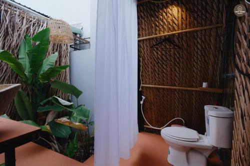a bathroom with a toilet and a plant at mango house, hide out Can Tho in Ấp Bình Thương