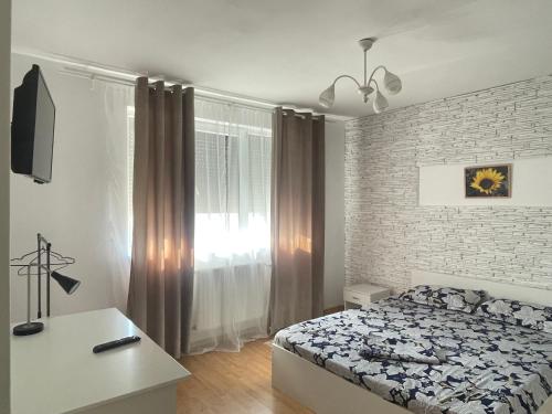a bedroom with a bed and a brick wall at Casa Nich in Mangalia