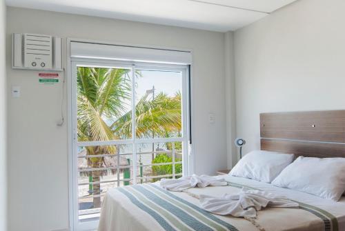 um quarto com uma cama e uma grande janela em Pousada Holiday em Florianópolis