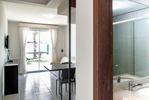 a bathroom with a table and a glass shower door at Pousada Holiday in Florianópolis