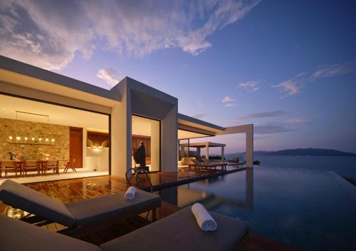a villa with a swimming pool at night at Cape Azure Resort Samui by Thalsea in Plai Laem