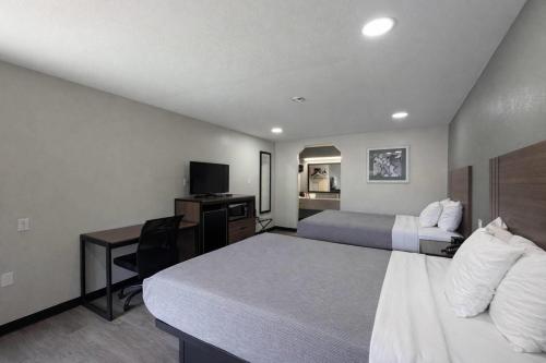 a hotel room with two beds and a desk at Quality Inn Mt Pleasant in Mount Pleasant