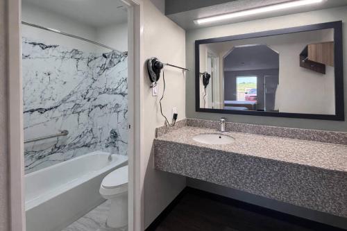 a bathroom with a sink and a toilet and a mirror at Quality Inn Mt Pleasant in Mount Pleasant