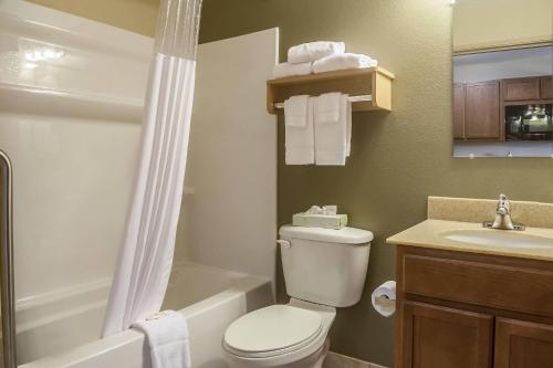 a bathroom with a toilet and a sink and a shower at Suburban Studios Triadelphia - Wheeling at The Highlands in Triadelphia