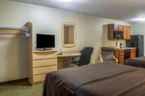 a hotel room with a bedroom with a desk and a computer at Suburban Studios Triadelphia - Wheeling at The Highlands in Triadelphia