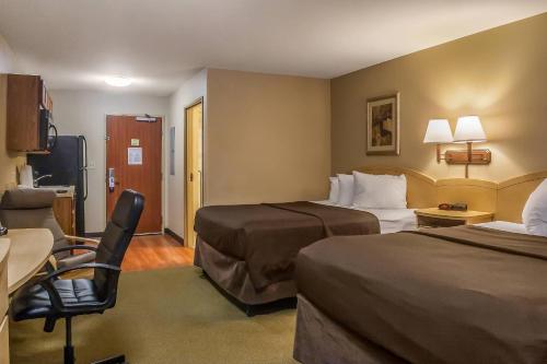 a hotel room with two beds and a chair at Suburban Studios Triadelphia - Wheeling at The Highlands in Triadelphia
