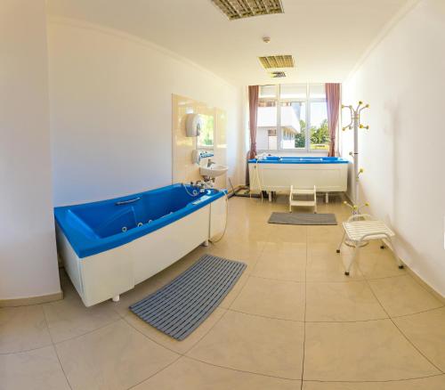 a bathroom with a large tub and a sink at Hotel San Terme Laktaši in Laktaši