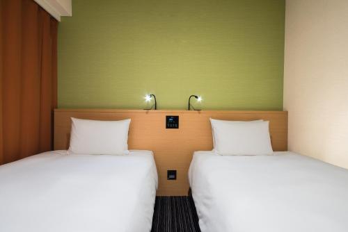 two beds sitting next to each other in a room at the b ikebukuro in Tokyo