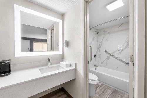 a bathroom with a sink and a toilet and a mirror at Quality Inn Odessa near University in Odessa