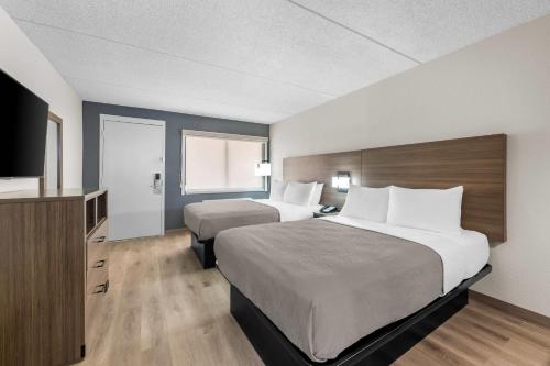a hotel room with two beds and a flat screen tv at Quality Inn Odessa near University in Odessa