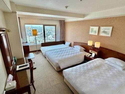 a hotel room with two beds and a window at Bellevue Garden Hotel Kansai International Airport in Izumi-Sano