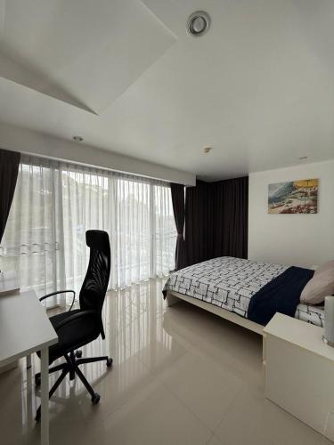 a bedroom with a bed and a desk and a chair at Big Apartament with two bedrooms Karon in Phuket
