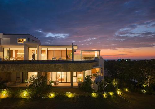 a night view of a house with lights at Cape Azure Resort Samui by Thalsea in Plai Laem