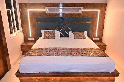 a bedroom with a large bed with a wooden headboard at HOMESTAY KT palace in Varanasi