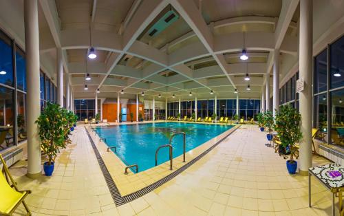 an indoor pool with plants in a large building at Hotel San Terme Laktaši in Laktaši
