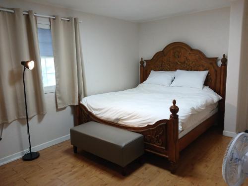 a bedroom with a bed with a wooden headboard and a chair at Park Vill 202 in Pyeongtaek