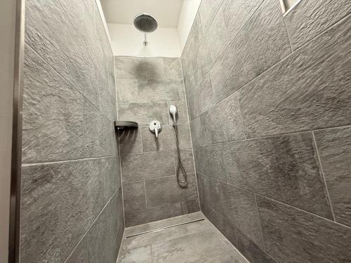 a bathroom with a shower with a phone on the wall at Inselbutze Fehmarn in Fehmarn