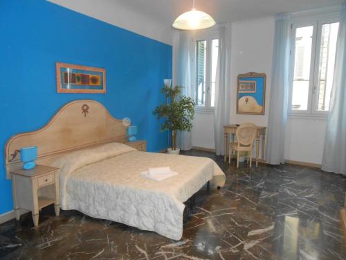 1 dormitorio con cama y pared azul en Scala Apartment, en Florencia