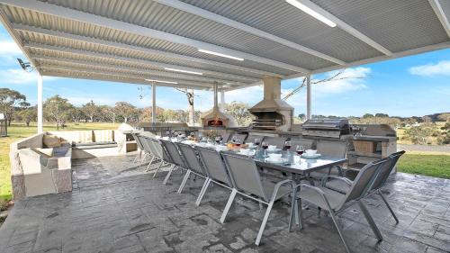 a patio with a table and chairs and a grill at Sutton Forest Retreat The Hideaway in Sutton Forest