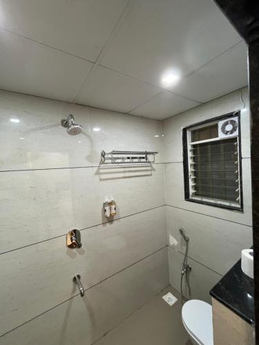 a bathroom with a toilet and a sink at Hotel Lotus Suites in Miraj