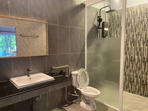 a bathroom with a sink and a toilet and a shower at The Coconut House Hotel in Battambang