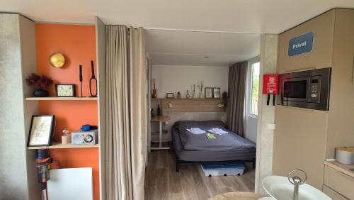 a small room with a bed and orange walls at Tiny House in Kropswolde