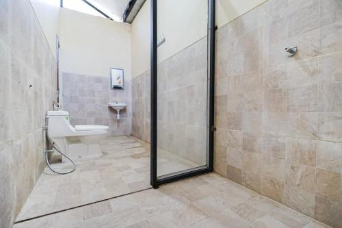 a bathroom with a shower with a toilet and a sink at Villa Maurine Prambanan in Jogonalan