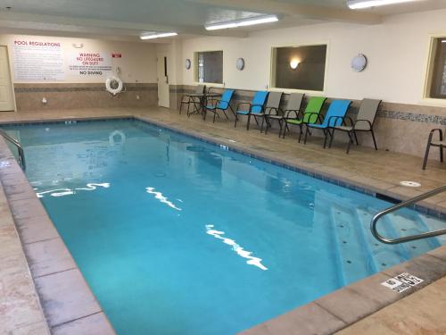 a large swimming pool with blue water and chairs at Victorian Inn in Beatrice