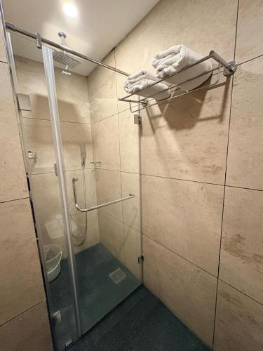 a shower stall with a glass door in a bathroom at Beeza Clubhouse in Kottayam