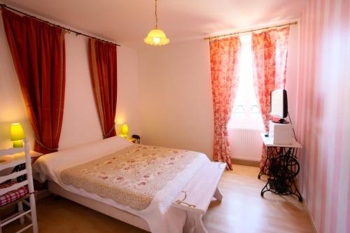 a bedroom with a white bed and red curtains at Logis Auberge La Cremaillere in Villandraut