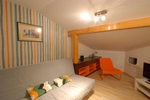 un soggiorno con divano e sedia arancione di Viva Maria Zakopane a Zakopane