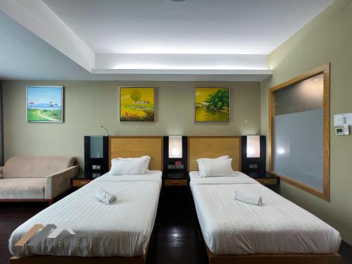 a hotel room with two beds and a projection screen at Evernent Meritz in Miri