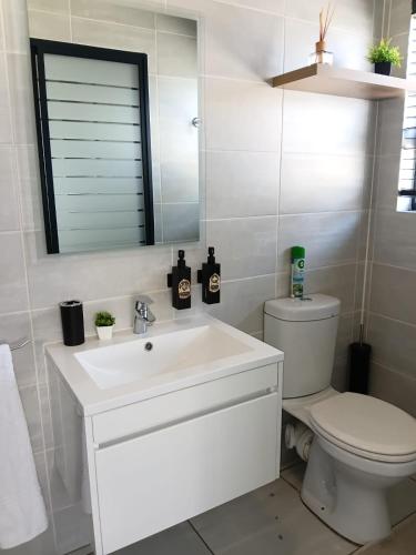 a white bathroom with a toilet and a sink at URlyfstyle Kikuyu Escape Waterfall Mall of Africa in Midrand