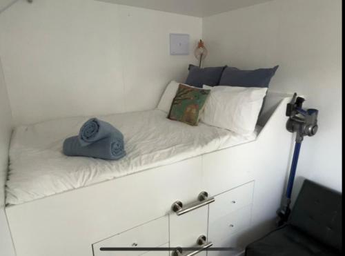 a bed with a hat sitting on top of it at The Bothy by the lake in Lake Hāwea