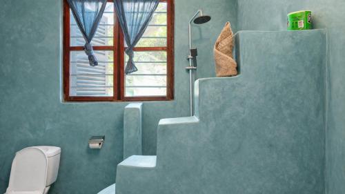 a bathroom with a staircase and a toilet and a window at New Teddy's on the Beach in Jambiani