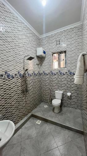 un baño con inodoro blanco y lavabo en Yoyo Celestial Home, en Arusha